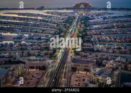 Dubai, Vereinigte Arabische Emirate - 05 2021. Dez.: Luftaufnahme der Palm Jumeirah am Abend in Dubai, Langzeitfoto mit Lichtpfaden im Auto Stockfoto