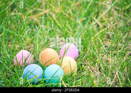 Farbenfrohe ostereier im grünen Gras, ostertradition Stockfoto