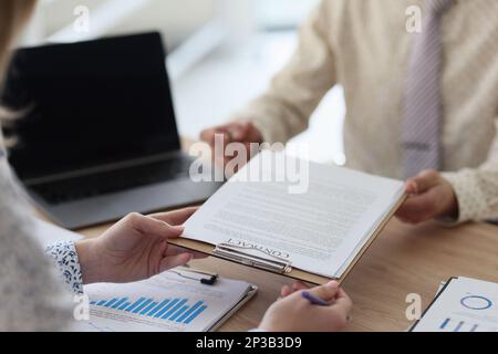 Der Manager übergibt seinem Kunden Vertragspapiere zur Unterzeichnung einer Nahaufnahme. Stockfoto