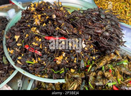 Eine große Schüssel sautierter Tarantelspinnen auf dem Skun Insektenmarkt in Kambodscha. Stockfoto