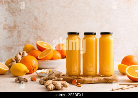 Smoothie. Gesunder, frischer, roher Detox-Citrus-Smoothie mit Orange, Zitrone, Ingwer und Kurkuma in einer Glasflasche auf einem Tisch. Gesunde Ernährung vegane Lebensmittel voll Stockfoto