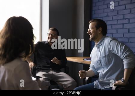 Business-Team aus fröhlichen Mitarbeitern, die ein Brainstorming zu einem Meeting durchführen Stockfoto