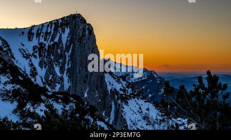 Die Sonne geht an einem weiteren schneebedeckten Tag auf dem Gipfel des Feuerkogul im österreichischen Salzkammergut unter Stockfoto