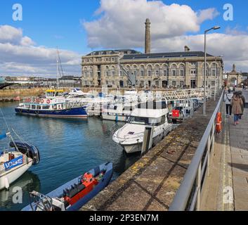 Der Yachthafen am Becken im Royal William Yard in Stonehouse Plymouth. Die starken Sonnenlichter ermutigen Besucher, einem kühlen Februar danach zu trotzen Stockfoto