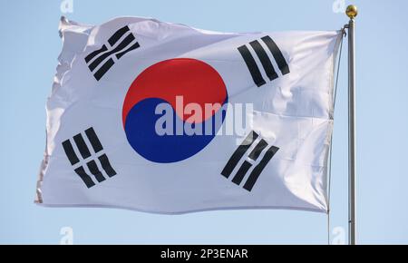 Die südkoreanische Flagge fliegt in Seoul. Die Nationalflagge Südkoreas, auch bekannt als Taegukgi und umgangssprachlich auch als die Flagge Koreas bekannt, hat drei Teile: Einen weißen rechteckigen Hintergrund, einen roten und blauen Taegeuk in der Mitte, begleitet von vier schwarzen Trigrammen, eines in jeder Ecke. Flaggen ähnlich dem aktuellen Taegeukgi wurden von der Joseon-Dynastie, dem Koreanischen Reich und der koreanischen Exilregierung während der japanischen Herrschaft als Nationalflagge Koreas verwendet. Südkorea nahm die Taegukgi als nationale Flagge an, als es am 15. August 1945 die Unabhängigkeit von Japan erlangte. Stockfoto