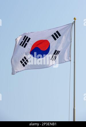 Die südkoreanische Flagge fliegt in Seoul. Die Nationalflagge Südkoreas, auch bekannt als Taegukgi und umgangssprachlich auch als die Flagge Koreas bekannt, hat drei Teile: Einen weißen rechteckigen Hintergrund, einen roten und blauen Taegeuk in der Mitte, begleitet von vier schwarzen Trigrammen, eines in jeder Ecke. Flaggen ähnlich dem aktuellen Taegeukgi wurden von der Joseon-Dynastie, dem Koreanischen Reich und der koreanischen Exilregierung während der japanischen Herrschaft als Nationalflagge Koreas verwendet. Südkorea nahm die Taegukgi als nationale Flagge an, als es am 15. August 1945 die Unabhängigkeit von Japan erlangte. Stockfoto