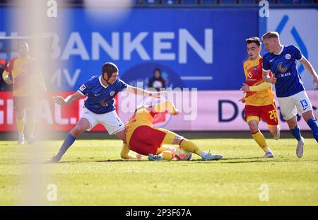 Rostock, Deutschland. 05. März 2023. Fußball: 2. Bundesliga, Hansa Rostock - Karlsruher SC, Matchday 23, Ostseestadion. Rostocks Damian Roßbach (2. von links) und Karlsruher Mikkel Kaufmann (Mitte) kämpfen um den Ball. Kredit: Gregor Fischer/dpa - WICHTIGER HINWEIS: Gemäß den Anforderungen der DFL Deutsche Fußball Liga und des DFB Deutscher Fußball-Bund ist es verboten, im Stadion aufgenommene Fotos und/oder das Spiel in Form von Sequenzbildern und/oder videoähnlichen Fotoserien zu verwenden oder verwenden zu lassen./dpa/Alamy Live News Stockfoto