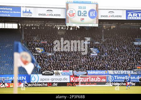 Rostock, Deutschland. 05. März 2023. Fußball: 2. Bundesliga, Hansa Rostock - Karlsruher SC, Matchday 23, Ostseestadion. Fans von Rostock sehen sich das Spiel von der Tribüne aus um 0:2. Kredit: Gregor Fischer/dpa - WICHTIGER HINWEIS: Gemäß den Anforderungen der DFL Deutsche Fußball Liga und des DFB Deutscher Fußball-Bund ist es verboten, im Stadion aufgenommene Fotos und/oder das Spiel in Form von Sequenzbildern und/oder videoähnlichen Fotoserien zu verwenden oder verwenden zu lassen./dpa/Alamy Live News Stockfoto