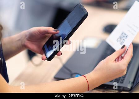 Scannen von QR-Code-Tickets für Ereignisse. Ein Geschäftsmann, der sich mit seinem Smartphone für eine Geschäftskonferenz anmeldet Stockfoto