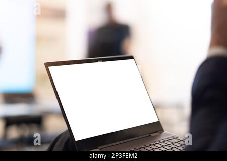 IT-Software-Ingenieur, der an einem Laptop an seinem Schreibtisch arbeitet. Vielfältiger Arbeitsplatz mit Profis. Vorderansicht Stockfoto