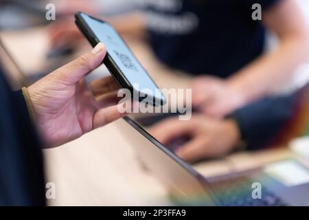 Scannen von QR-Code-Tickets für Ereignisse. Ein Geschäftsmann, der sich mit seinem Smartphone für eine Geschäftskonferenz anmeldet Stockfoto