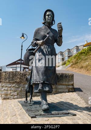 Bronzeskulptur der Geologin Mary Anning mit einem Fossil an der Jurassic Coast, Lyme Regis, Dorset, England, Großbritannien Stockfoto