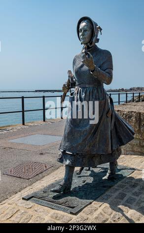 Bronzeskulptur der Geologin Mary Anning mit einem Fossil an der Jurassic Coast, Lyme Regis, Dorset, England, Großbritannien Stockfoto