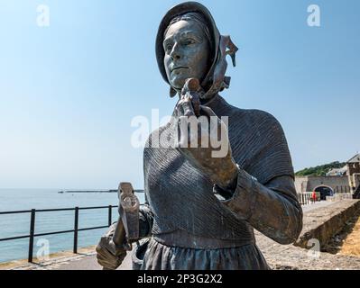 Bronzeskulptur der Geologin Mary Anning mit einem Fossil an der Jurassic Coast, Lyme Regis, Dorset, England, Großbritannien Stockfoto