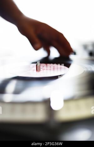 DJ mixt Schallplatten auf Hip-Hop-Party. Nahaufnahme eines Disc Jockey, der Musik auf einer hellen Konzertbühne spielt Stockfoto