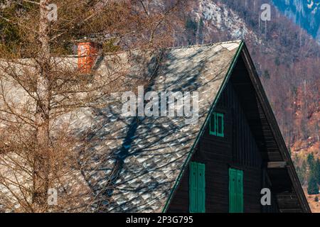 Traditionelles slowenisches hölzernes Gebirgshaus im Triglav-Nationalpark am sonnigen Wintertag Stockfoto