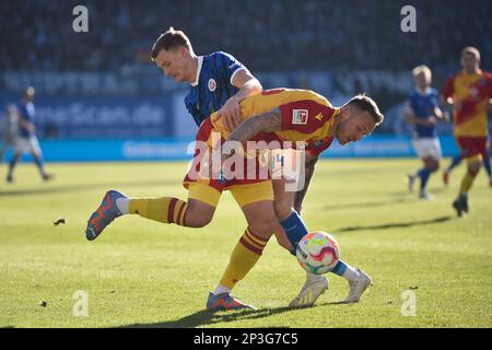 Rostock, Deutschland. 05. März 2023. Fußball: 2. Bundesliga, Hansa Rostock - Karlsruher SC, Matchday 23, Ostseestadion. Rostocks Svante Ingelsson (Rücken) und Karlsruhes Marcel Franke kämpfen um den Ball. Kredit: Gregor Fischer/dpa - WICHTIGER HINWEIS: Gemäß den Anforderungen der DFL Deutsche Fußball Liga und des DFB Deutscher Fußball-Bund ist es verboten, im Stadion aufgenommene Fotos und/oder das Spiel in Form von Sequenzbildern und/oder videoähnlichen Fotoserien zu verwenden oder verwenden zu lassen./dpa/Alamy Live News Stockfoto