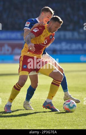 Rostock, Deutschland. 05. März 2023. Fußball: 2. Bundesliga, Hansa Rostock - Karlsruher SC, Matchday 23, Ostseestadion. Rostocks Svante Ingelsson (Rücken) und Karlsruhes Marcel Franke kämpfen um den Ball. Kredit: Gregor Fischer/dpa - WICHTIGER HINWEIS: Gemäß den Anforderungen der DFL Deutsche Fußball Liga und des DFB Deutscher Fußball-Bund ist es verboten, im Stadion aufgenommene Fotos und/oder das Spiel in Form von Sequenzbildern und/oder videoähnlichen Fotoserien zu verwenden oder verwenden zu lassen./dpa/Alamy Live News Stockfoto