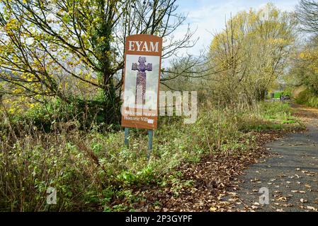 Ein Schild für das Dorf Eyam mit der Aufschrift „Eyam - Welcome to our Historic Village“. Ein britisches Dorf, bekannt für die Ausbreitung der Bubonischen Pest. Stockfoto