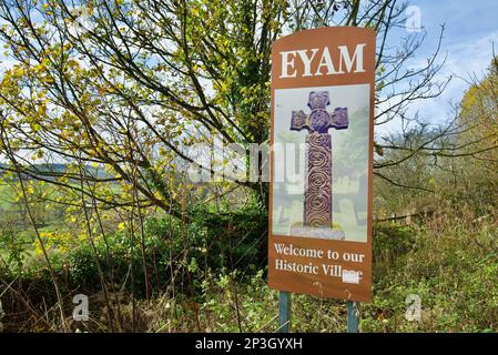 Ein Schild für das Dorf Eyam mit der Aufschrift „Eyam - Welcome to our Historic Village“. Ein britisches Dorf, bekannt für die Ausbreitung der Bubonischen Pest. Stockfoto