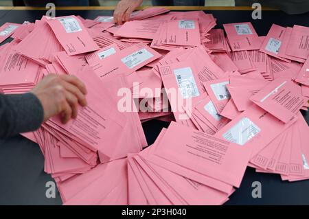 05. März 2023, Hessen, Frankfurt/Main: Wahlhelfer sortieren Umschläge für abwesende Wahlurnen auf einem Tisch in einer Ausstellungshalle. Etwa 509.000 Einwohner Frankfurts werden aufgefordert, für einen neuen Stadtführer zu stimmen. Foto: Arne Dedert/dpa Stockfoto