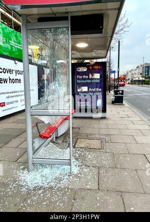 Ein verwundeter Busbunker in Acton Town London. Zerbrochenes Glas liegt auf dem Bürgersteig, als zwei Glasscheiben zertrümmert wurden. Stockfoto