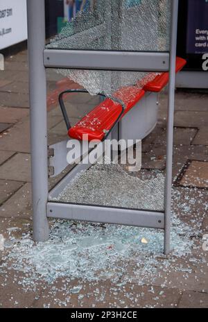 Ein verwundeter Busbunker in Acton Town London. Zerbrochenes Glas liegt auf dem Bürgersteig, als zwei Glasscheiben zertrümmert wurden. Stockfoto