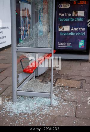 Ein verwundeter Busbunker in Acton Town London. Zerbrochenes Glas liegt auf dem Bürgersteig, als zwei Glasscheiben zertrümmert wurden. Stockfoto