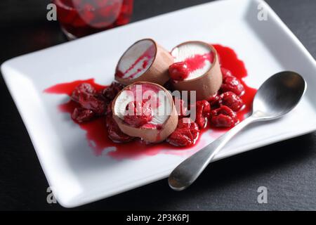Scheiben Schokoladeneis serviert mit Kirschmarmelade auf einem rechteckigen weißen Gericht Stockfoto