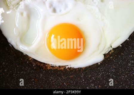 Nahaufnahme eines farbenfrohen Hühnereies, das in einer Pfanne gebraten wird Stockfoto