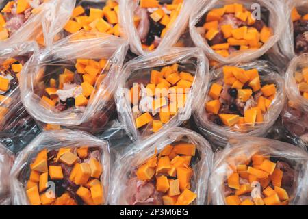 Zubereitung von Schüsseln mit natürlichem rohem Heimtierfutter zu Hause, Zubereitung von gesunder roher Kotelett für Katzen Hunde, mit Ente, truthahn, Innereien, Fleisch, Vegetation Stockfoto