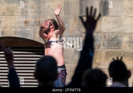 Straßenunterhalter, der während des Festivals mit einem Tennisschläger auftritt, Royal Mile, Edinburgh, Schottland, Großbritannien Stockfoto