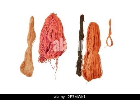 Das Garn wird an einem Seil getrocknet, isoliert auf weißem Hintergrund. Unter dem Zelt trocknete Fadenroste. Stockfoto