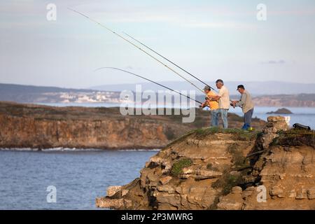 Fischer auf den Klippen entlang des Cabo Carvoeiro, die im Atlantik, in Peniche, in der Zentralregion, Portugal, Europa fischen Stockfoto