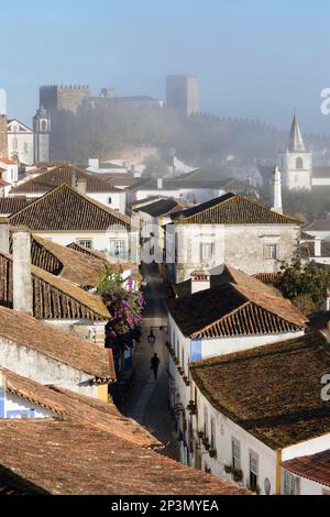 Sehen Sie die Rua Direita in der Altstadt und die Mauern von Obidos im Morgennebel, Obidos, Zentralregion, Portugal, Europa Stockfoto