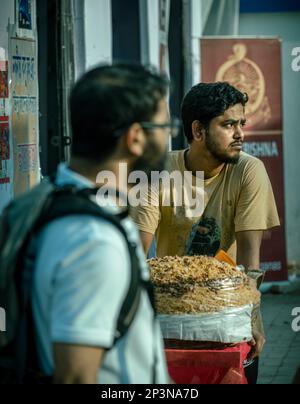 Kalkutta, Indien - 12. Februar 2023: Porträt eines jungen indianers, der "Ghoti Gorom" verkauft, einen bengalischen Snack aus Mottenbohnen, Gramm Mehl und Gewürzen Stockfoto