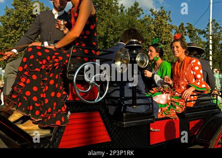 Feria de Abril (The April Fair). "El Real". Leute sitzen auf einer Pferdekutsche. Sevilla, Andalusien, Spanien. Stockfoto