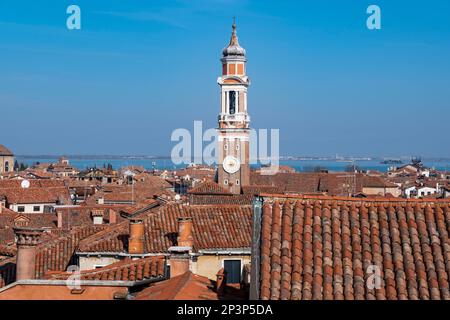 Ein Uhrenturm erhebt sich über den Dächern von Venedig, Italien Stockfoto