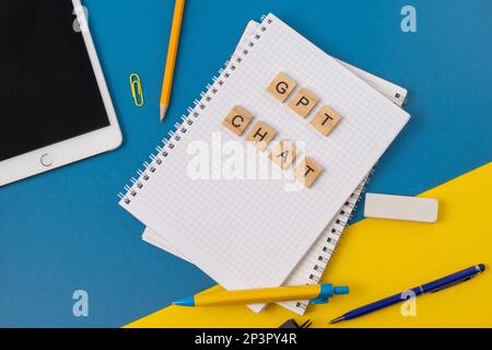 Arbeits- und Studienhintergrund mit Hilfe eines ChatGPT-bot. Wörter in Holzbuchstaben. Tischansicht mit freiem Notizbuchbereich. Chat-GPT zum Arbeiten und Erstellen. Ukraine, Kiew - 21. Februar 2023 Stockfoto