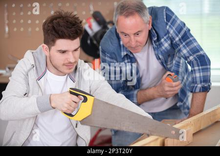 Der Mensch als Tischler beim konzentrischen Sägen von Holz Stockfoto