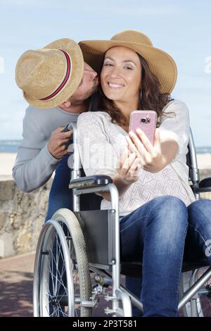 Ein Paar im Rollstuhl macht ein Selfie Stockfoto