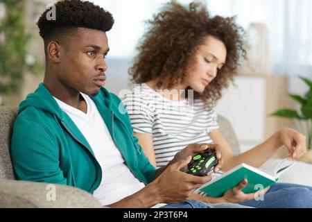 Bild eines jungen Paares, das still auf der Couch sitzt Stockfoto