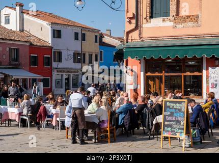 Speisen im Freien vor einem Restaurant in Burano, Ventian Lagune, Venedig, Italien. Stockfoto