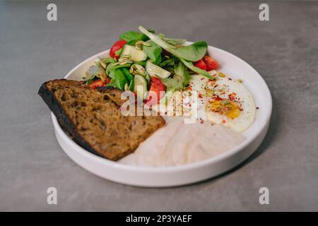 Speisen auf einem eleganten weißen Teller, Mittag- oder Abendessen. Köstliches Essen in einem Restaurant aus der Nähe. Stockfoto