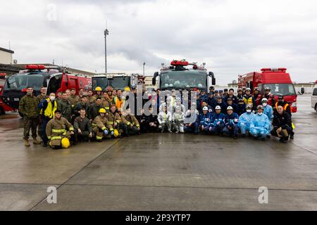 USA Marines, Matrosen und Ersthelfer der Marine Corps Air Station Iwakuni Fire and Emergency Services sowie Iwakuni City Fire und Japan Maritime Self-Defense Force Mitglieder posieren für ein Gruppenfoto nach einer Notfallschulung am MCAS Iwakuni, Japan, 10. Februar 2023. Diese Schulung ist eine jährliche Anforderung für Marines zur Rettung und Brandbekämpfung von Flugzeugen (Aircraft Rescue and Fibekighting, ARFF), bei der sie und das Personal der Feuerwehr und der Rettungsdienste von Iwakuni zusammenarbeiten, um die Bereitschaft und Effizienz bei der Reaktion auf Massenunfälle vor Ort in Vorbereitung auf potenzielle reale Szenarien zu verbessern. Stockfoto