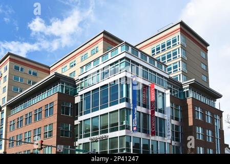ITHACA, NEW YORK - 26. FEBRUAR 2023: Moderne Gebäude in Downtown Ithaca mit Bannern für Cornell University, Hilton Garden Inn und Seneca Place. Stockfoto