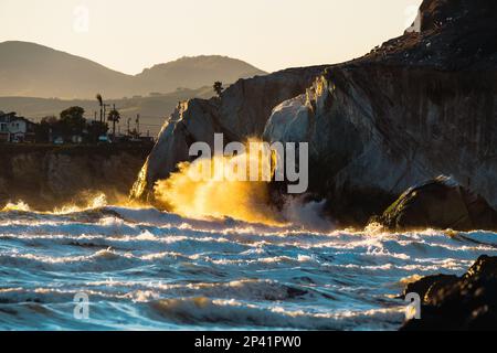 Die starke Meereswelle am Pismo Beach an der kalifornischen Zentralküste, die bei Sonnenuntergang auf den Felsen trifft, ist eine dramatische Meereslandschaft. Stockfoto