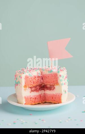 Festlicher Kuchen aus rosa Kuchen auf blauem Hintergrund. Das Konzept von Feiertag, Geburtstag, Jubiläum Stockfoto