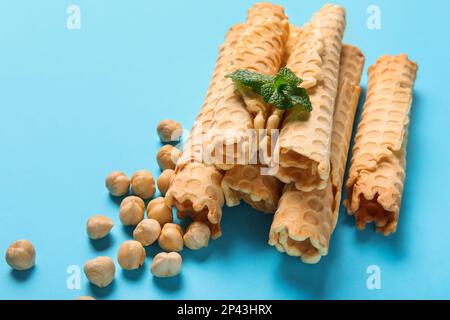 Köstliche Waffeln, Haselnüsse und Minze auf blauem Hintergrund Stockfoto