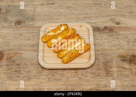 Ein paar Mozzarella-Stäbchen paniert und in Friteusöl gebraten Stockfoto